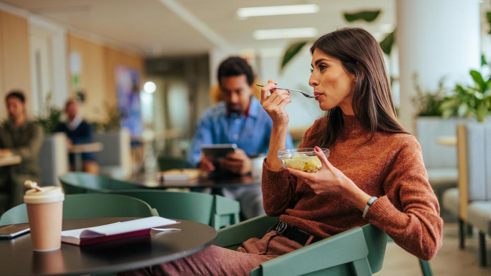 Mujer almorzando en la oficina.