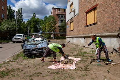 Two women collect rubble and other remains left by the Russian bombing that killed nine people in this neighborhood of Kharkiv in May, on July 30.